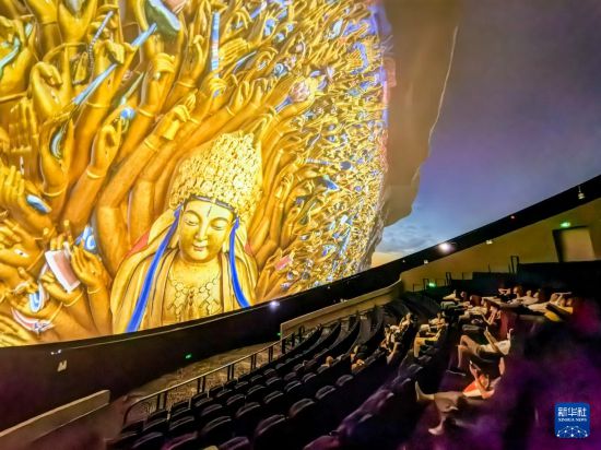   6月24日，游客在大足石刻景區觀看8K球幕電影。    新華社記者 唐奕 攝