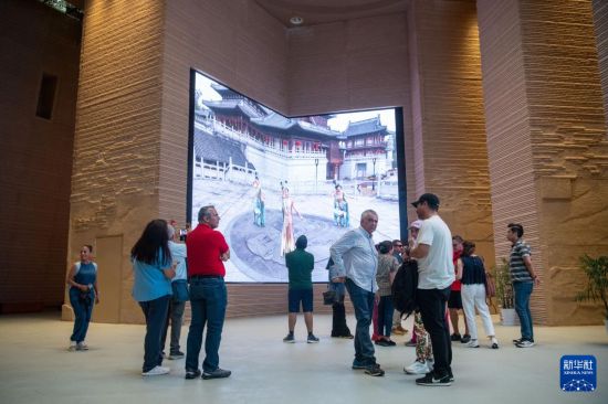   6月24日，游客在大足石刻景區觀賞數字影片。    新華社記者 唐奕 攝