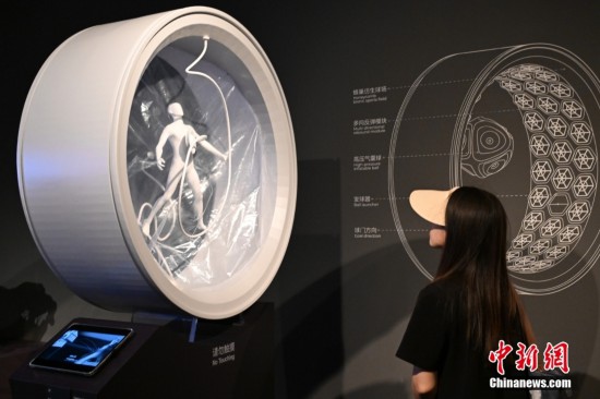 圖為參觀者觀看來自清華大學美術學院的實驗裝置《澡 AQUA》，該實驗探討了在太空如何實現自我清潔沐浴體驗。中新社記者 田雨昊 攝