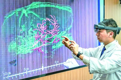 科研人員在展示通過混合現實技術，微米級呈現腦機接口裝置與大鼠大腦主要血管和腦組織的空間位置關系。新華社發