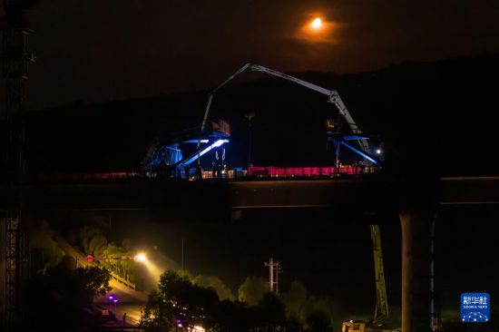 7月6日凌晨，在邵永高鐵跨S236省道大橋施工現場，中鐵五局工人進行連續梁合龍施工（無人機照片）。新華社記者 陳思汗 攝