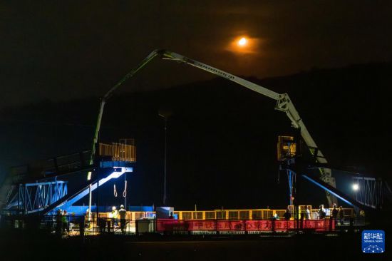 7月6日凌晨，在邵永高鐵跨S236省道大橋施工現場，中鐵五局工人進行連續梁合龍施工（無人機照片）。新華社記者 陳思汗 攝