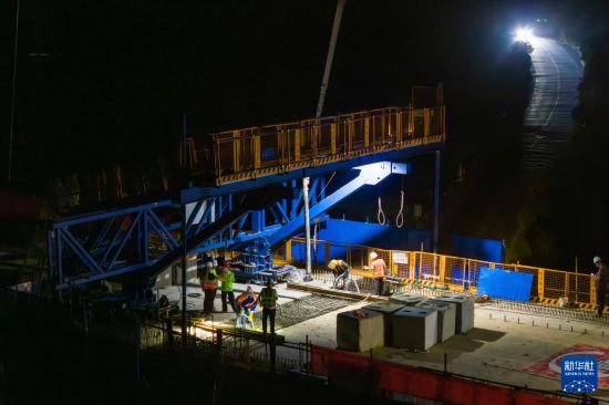 7月6日凌晨，在邵永高鐵跨S236省道大橋施工現場，中鐵五局工人進行連續梁合龍施工（無人機照片）。新華社記者 陳思汗 攝