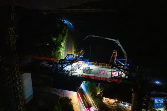 7月6日凌晨，在邵永高鐵跨S236省道大橋施工現場，中鐵五局工人進行連續梁合龍施工（無人機照片）。新華社記者 陳思汗 攝