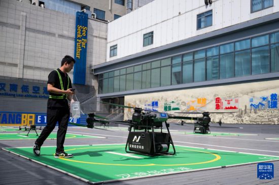 6月16日，在漢商低空港停機坪，一名工作人員給無人機裝配貨物。新華社記者 伍志尊 攝