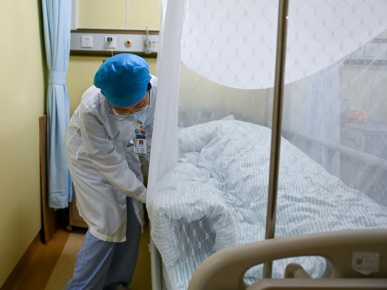 7月25日，南方醫科大學順德醫院的護士為患者整理床鋪蚊帳。新華社記者 肖恩楠 攝