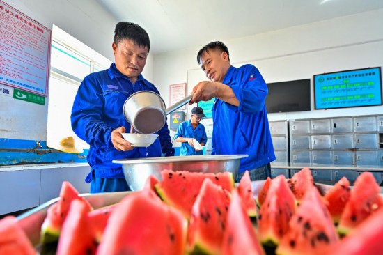 在天津長蘆海晶集團有限公司的鹽田作業現場，工人在休息區領取綠豆湯納涼解暑。新華社發（杜鵬輝 攝）