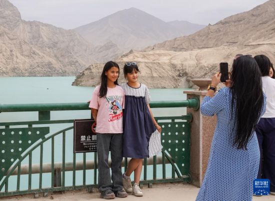 8月6日，游客在烏魯瓦提水利樞紐拍照留影。新華社記者 周佳誼 攝