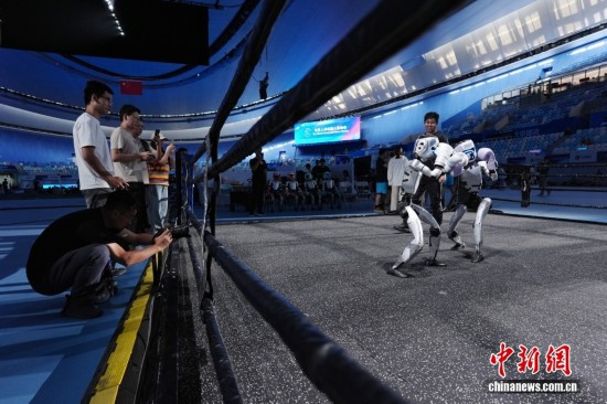 8月13日，在北京國家速滑館，兩臺宇樹科技機器人訓練自由搏擊項目。中新社記者 張祥毅 攝