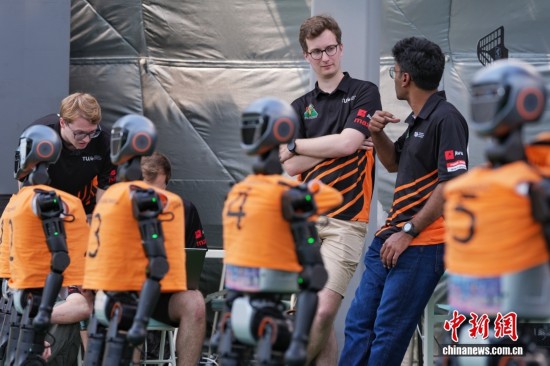 8月13日，在北京國家速滑館的人形機器人賽訓基地，來自荷蘭埃因霍芬理工大學的參賽隊員在交流中。中新社記者 張祥毅 攝