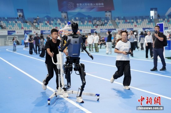 8月13日，在北京國家速滑館，工作人員訓練參加跑步項目的機器人。中新社記者 張祥毅 攝