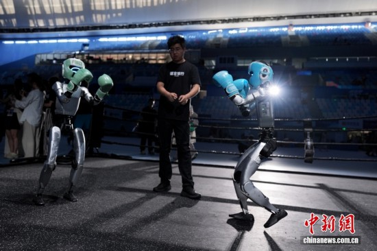 8月13日，在北京國家速滑館，兩臺宇樹科技機器人訓練自由搏擊項目。中新社記者 張祥毅 攝