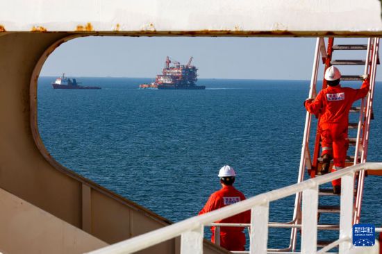 9月7日，工人穿梭在墾利6-1油田10-1北區塊Ⅱ期開發項目油氣平臺安裝作業現場。  新華社發（杜鵬輝攝）