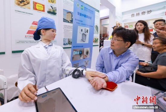 9月14日，觀眾體驗機器人把脈問診服務。