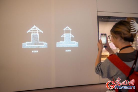 觀眾拍攝墻面投影演示墓葬槨室結構，數字技術幫助觀眾直觀理解考古剖面與墓室空間關系