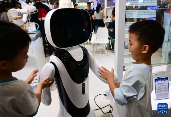 9月21日，小朋友在2025世界制造業大會智能機器人展區和一款機器人互動。