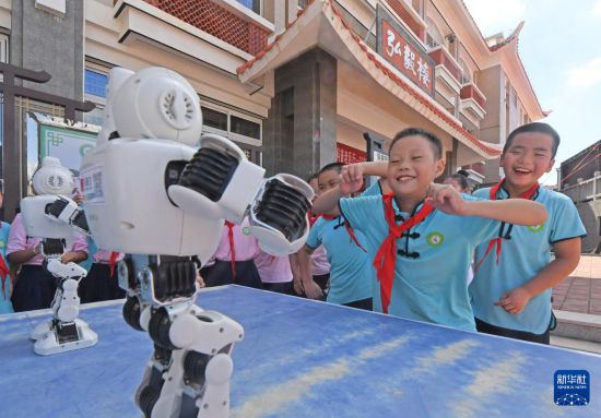 9月25日，在福建省泉州市泉港區后龍實驗小學，學生和跳舞機器人互動。新華社發（林弘梫攝）