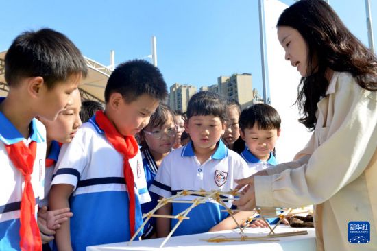 9月25日，四川省南充市南部縣紅巖子小學學生在聆聽科普工作者講解拱橋建造原理。新華社發（張櫪攝）