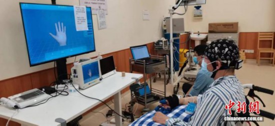 圖為腦機接口系統捕捉到患者的意圖后，控制手功能訓練設備實現患者手的運動。浙江省人民醫院供圖