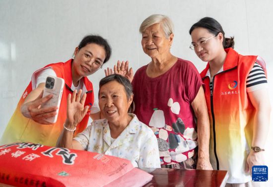 10月5日，江蘇省南通市通州區金新街道界北村志愿者幫助老人與遠在海外的子女進行視頻通話，“云端”相聚，共迎中秋。     新華社發（翟慧勇攝）