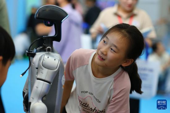 10月2日，在山東省第九屆滕州書展現場，小朋友與機器人互動。     新華社發（李志軍攝）
