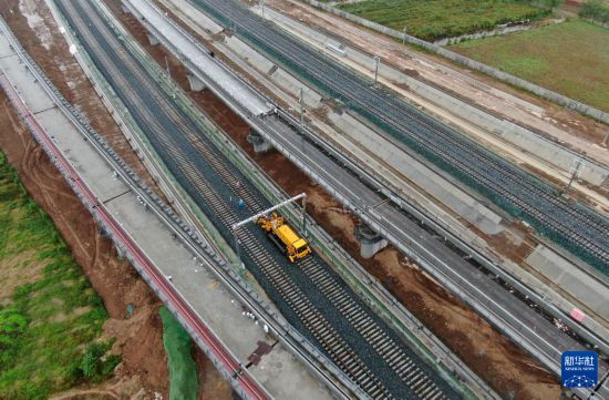10月11日，中鐵一局施工車輛在西康高鐵西安東站至牛背梁站區間鋪設無縫鋼軌（無人機照片）。新華社記者 李一博 攝