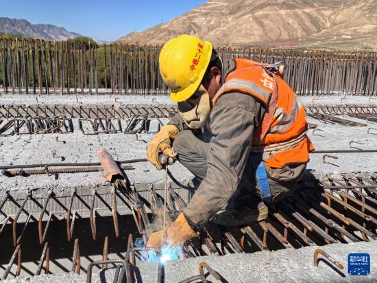 施工人員在薩熱路跨江大橋建設現場工作（10月13日攝）。     新華社發（帥卿 攝）