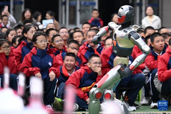 10月13日，新疆生產建設兵團第一中學學生在科技節開幕式上觀看智能機器人跳舞。     新華社記者 王菲 攝