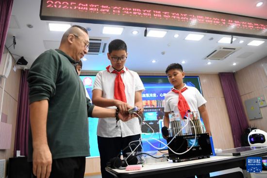 10月15日，在北京市海淀區第四實驗小學，人工智能社團的學生用其制作的“極客氫氧太陽能保健機”為現場嘉賓進行健康監測。  新華社記者 馬寧 攝