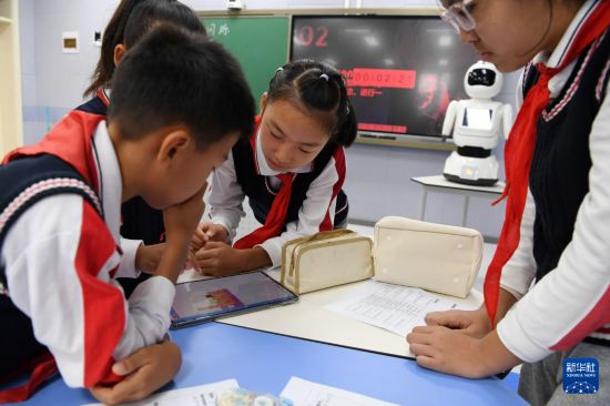 10月15日，在北京市海淀區第四實驗小學《閃爍信號》主題人工智能公開課上，學生們編寫程序。  新華社記者 馬寧 攝