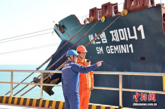 圖為港口工作人員盯控輪船作業。