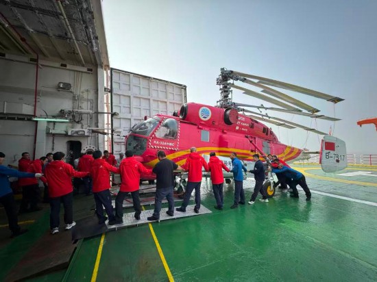 11月1日，中國第42次南極考察隊隊員們齊心協力運送直升飛機進入船上倉庫。新華社記者 顧天成 攝