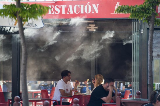 2025年9月17日，在西班牙馬德里，顧客在水霧裝置附近用餐。新華社發（古斯塔沃·巴連特攝）